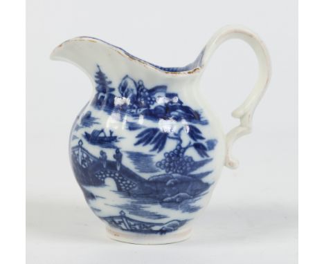 A Caughley helmet shaped cream jug with fluted moulding and double scrolling handle. Printed in blue with a chinoiserie lands