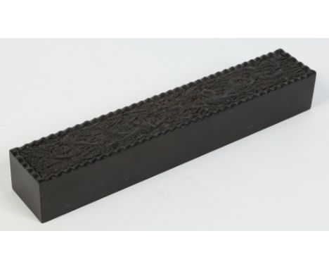 A Chinese hardwood scroll box with sliding cover possibly of Zitan wood. Carved to the top with a pair of confronting fierce 