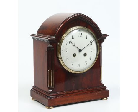 A Victorian mahogany lancet shaped mantel clock. With carved mouldings, brass inlaid reeded and canted corners and raised ove