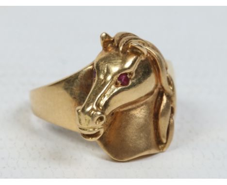 An 18 carat gold gentlemans equestrian signet ring. Formed as a stallions head and set with ruby eyes. 8.62 grams, ring size 