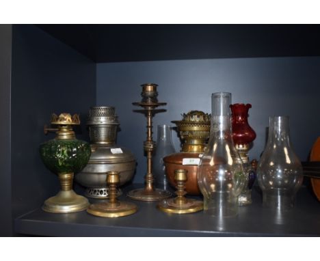 A collection of Vintage and antique oil lamps, chimneys, and candlestick holders some having arts and crafts styling and othe