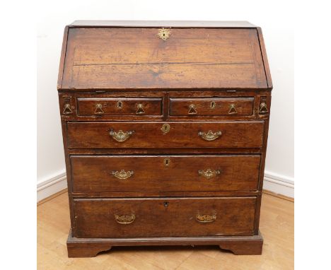 A 17th century and later oak bureau, the sloping fall front enclosing a fitted interior with various pigeon holes, over two s