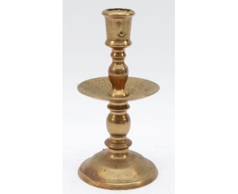 A mid 17th Century Dutch cast brass 'Heemskirk' candlestick, with turned stem, wide central drip pan and mound base, 19.5cm.