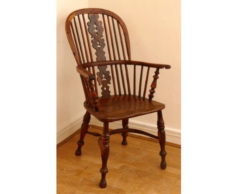 A 19th century yew wood and elm Windsor chair, hoop stick back with pierced splat, saddle seat raised on ring turned supports