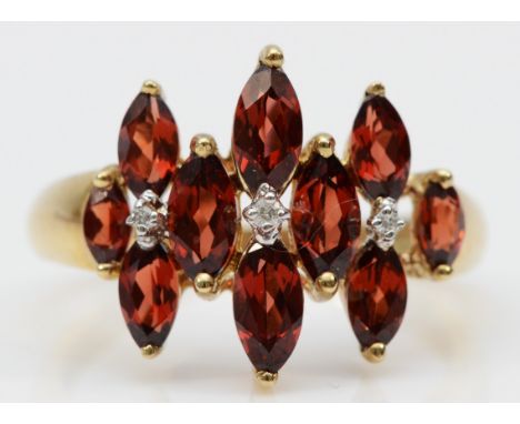 A 9ct gold garnet and diamond dress ring, marquise cut garnets with three diamonds, T, 3.6g