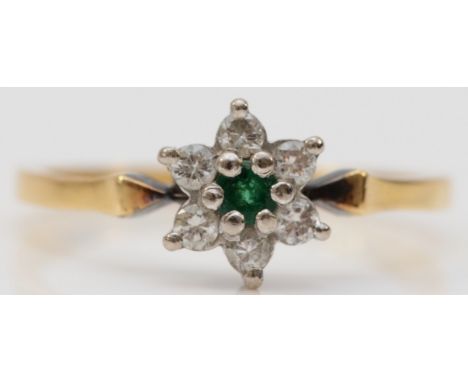 An 18ct gold diamond and emerald floral cluster ring, a single emerald flanked by brilliant cut diamonds, O 1/2, 2.5g