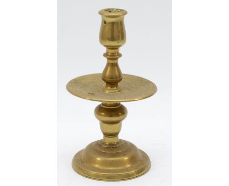 A mid 17th Century Dutch cast brass 'Heemskirk' candlestick, with turned stem, wide central drip pan and mound base, 19cm.