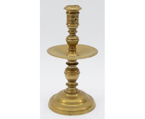 A mid 17th Century Dutch cast brass 'Heemskirk' candlestick, with turned stem, wide central drip pan and mound base, 22cm.