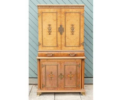 An Italian burr walnut with brass applied mounts drinks cabinet, the cupboard doors opening to reveal a fitted mirrored inter