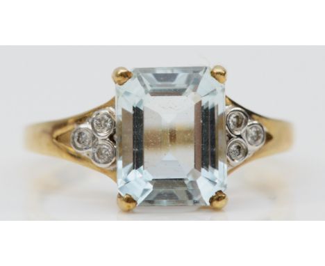 A 9ct gold emerald cut aquamarine and diamond dress ring, 10mm x 7mm aquamarine, three diamonds on each shoulder, O 1/2, 2.5g
