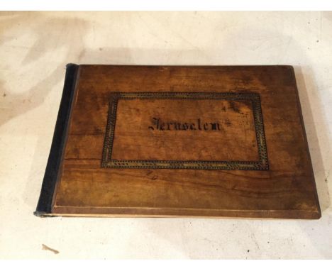 A SMALL OLIVE WOOD COVERED BOOK PRINTED ON THE COVER " JERUSALEM "AND INSCRIBED ON THE FRONTISPIECE " FLOWERS FROM THE HOLY L