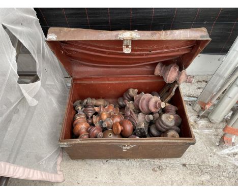 A VINTAGE TIN TRUNK CONTAINING TURNED FURNITURE FEET AND STAIR TOPS 