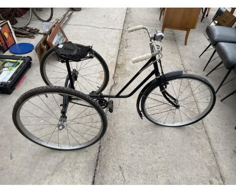 A VINTAGE THREE WHEELED BIKE 