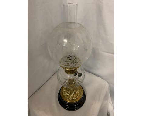 A GLASS AND BRASS OIL LAMP ON A METAL BASE, COMPLETE WITH A GLASS SHADE WITH FLOWER DESIGN H: 58CM 