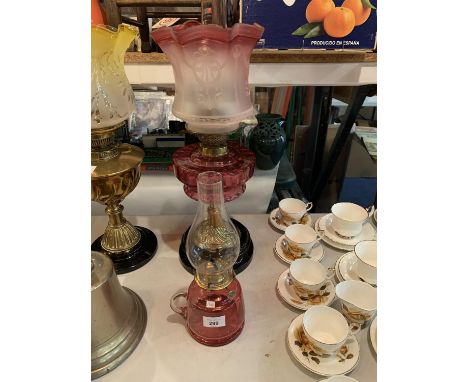 A RED GLASS AND METAL OIL LAMP AND A MINATURE EXAMPLE 