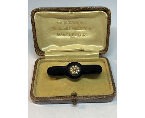 A 9 CARAT GOLD MOUNTED JET BROOCH WITH SEED PEARL ROSETTE 