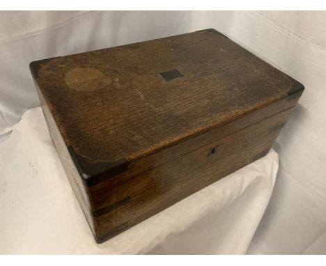 A VINTAGE OAK WRITING SLOPE WITH DECORATIVE IRON CORNERS WITH VARIOUS EPHEMERA 