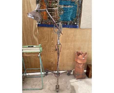 AN INDUSTRIAL STYLE THEATRE LIGHT ON AN INDUSTRIAL THREE WHEELED BASE 