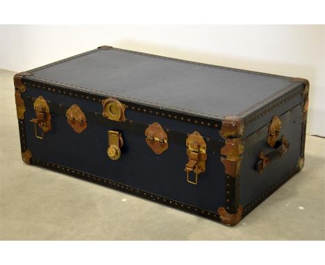 A black studded travel trunk with metal clasps and leather handles. 34cm x 90cm x 51cm.