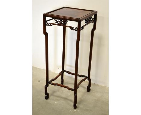 A Chinese carved rosewood plant stand with open scroll work frieze and shaped supports united by shape stretchers. Height 102