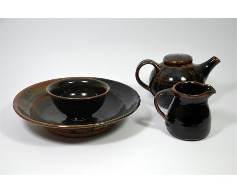 A group of studio pottery ware by Jim Malone (b.1946), including a teapot and cover, a bowl, a dish and a jug, with a black s