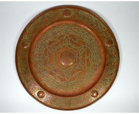 A Keswick School of Industrial Arts copper charger with a Celtic design, the central roundelle written 'In Mem Keswick August