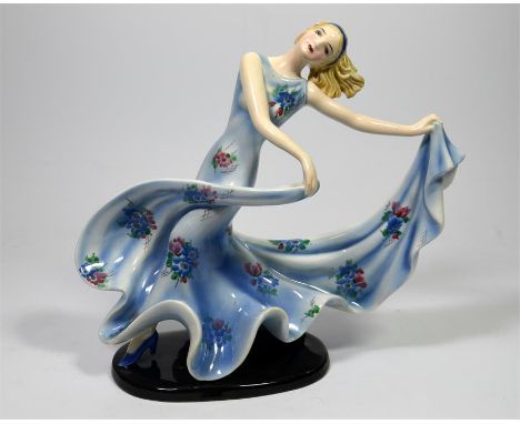 A Goldscheider figure of a female dancer in a long blue floral print dress designed by Stefan Dakon. Model 7078 272 2. Circa 