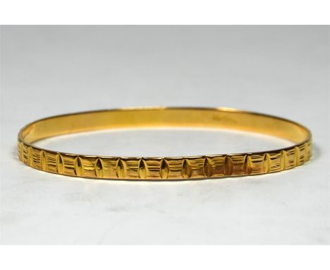 An oval engraved bangle, unmarked, thought to be 22ct. 17.3 grams.