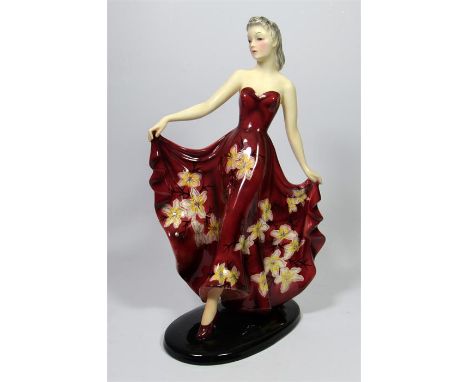 A large Goldscheider figure of a woman in a long floral dress, designed by Stefan Dakon. Model 8483 101 2. Impressed and prin