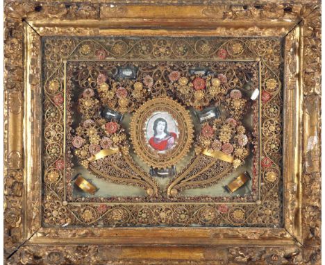 A late 18th/early 19th century, French, rolled paper reliquary, centered with an ink and wash portrait of a saint in oval gil