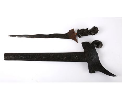 An Indonesian kris, the wavy blade with attractive pamor pattern, the hilt and sheath of ornately carved hardwood, dagger len