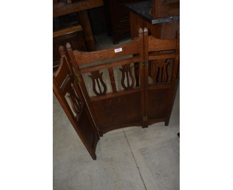 An early C20th oak 3 tier fold fire screen having lyre decoration