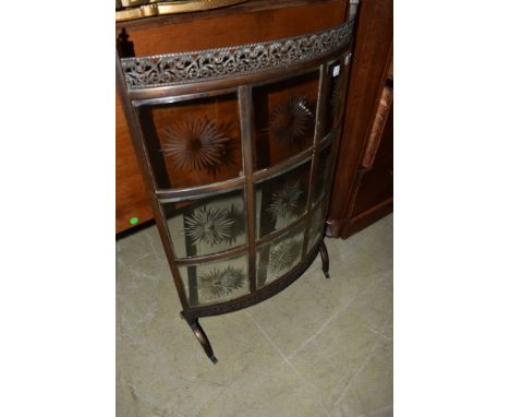 An Edwardian burnished metal bow front fire screen having cut glass panels