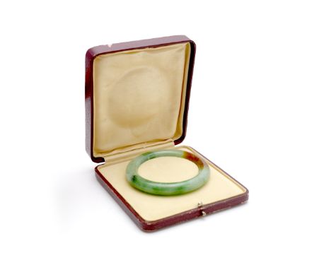 A Chinese spinach green and brown jade bangle 19th Century 8cm diameter in red leather case