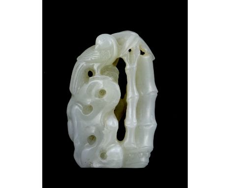 A Chinese white jade pendant 19th Century in the form of a magpie perched on a rock amongst bamboo, 4.5cm high