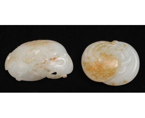 Two Chinese white and rust tinted jade pebbles 19th Century the first carved as a ruyi fungus and mushrooms, the second carve