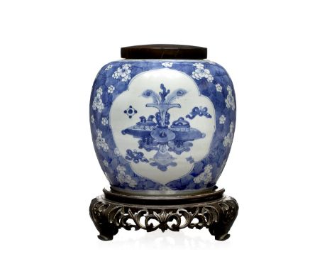 A Chinese blue and white ginger jar Kangxi (1662-1722) decorated with four panels of antiques within a border of prunus bloss