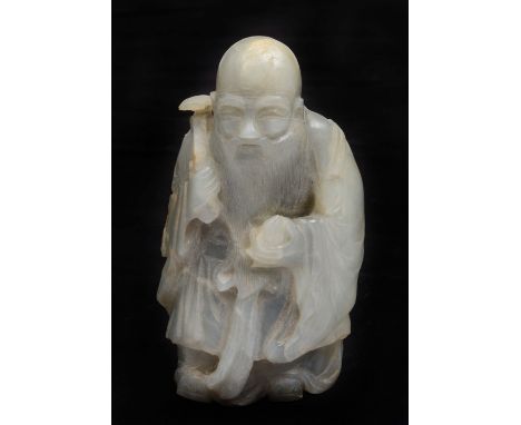 A Chinese pale bluish grey jade figure 19th Century in the form of Shou Lao holding a peach and ruyi sceptre, 12cm high