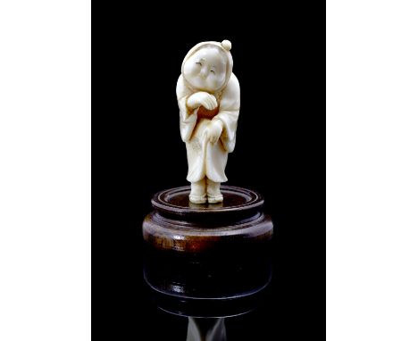 A Japanese ivory netsuke Meiji period (1868-1912) modelled as a standing okame holding her robe together and concerned about 