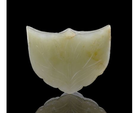 A green jade dagger hilt 18th Century decorated with Indian flowers to each side, 4cm high, 5cm across