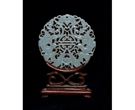 A Chinese pierced and carved mutton fat jade medallion circa 1800 carved with phoenix, bat and lotus encircling a Shou charac