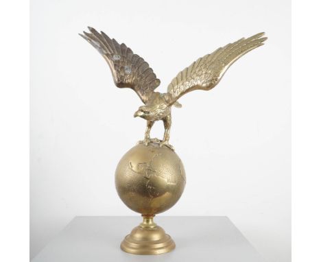 Finely cast brass sculpture of an eagle in mid-flight perched atop a globe, with wings dramatically outstretched. The globe f