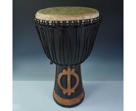 Traditional handcrafted djembe drum made in Ghana, featuring a goblet-shaped body carved from wood. The base is adorned with 