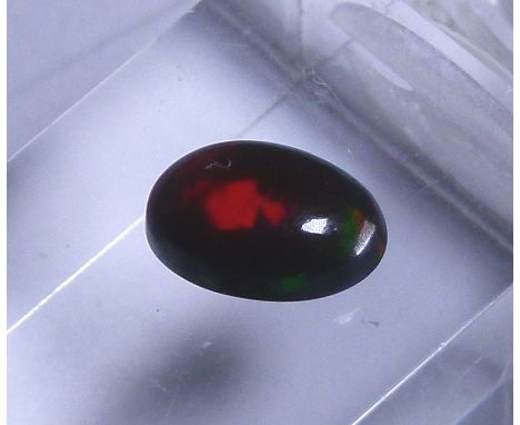 Oval cut black opal, approximately 1.47 ct, 10.18 x  7.14 x 4.21 mm