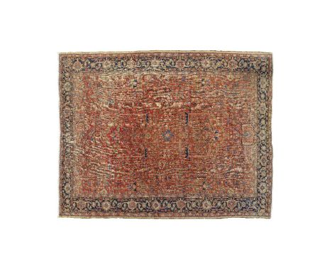 Tapis Hériz XIXe siècleFond rouge chargé de tiges fleuries stylisées à une bordure de rinceaux sur fond bleu.395 x 315 cmAn a