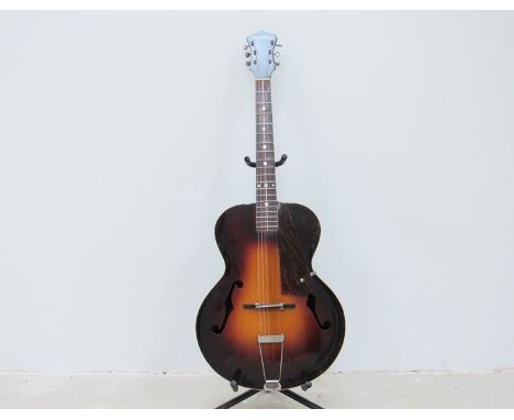 A 1930's Gibson Cromwell acoustic guitar, the sunburst top with twin f-holes and tortoiseshell pick guard. The decal to heads