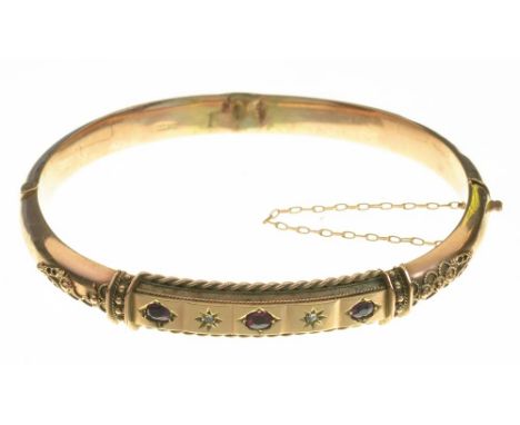 A RUBY AND ROSE CUT DIAMOND BANGLE IN 9CT GOLD, CHESTER 1904, 8.5G++EVIDENCE OF SOLDER REPAIR AND SOME LIGHT DENTS