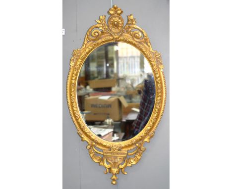 A VICTORIAN OVAL GILTWOOD AND COMPOSITION MIRROR, 89CM  H