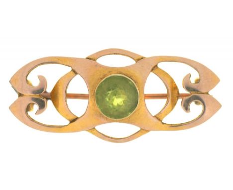 AN ART NOUVEAU PERIDOT BROOCH IN GOLD MARKED 15CT, 3.5 CM L APPROX, 4.5G++LIGHT WEAR CONSISTENT WITH AGE 