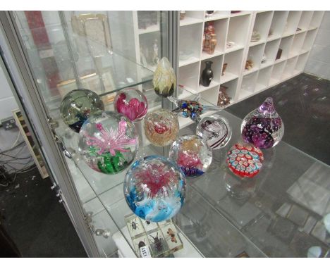 Eleven glass paperweights including Langham and Caithness pieces